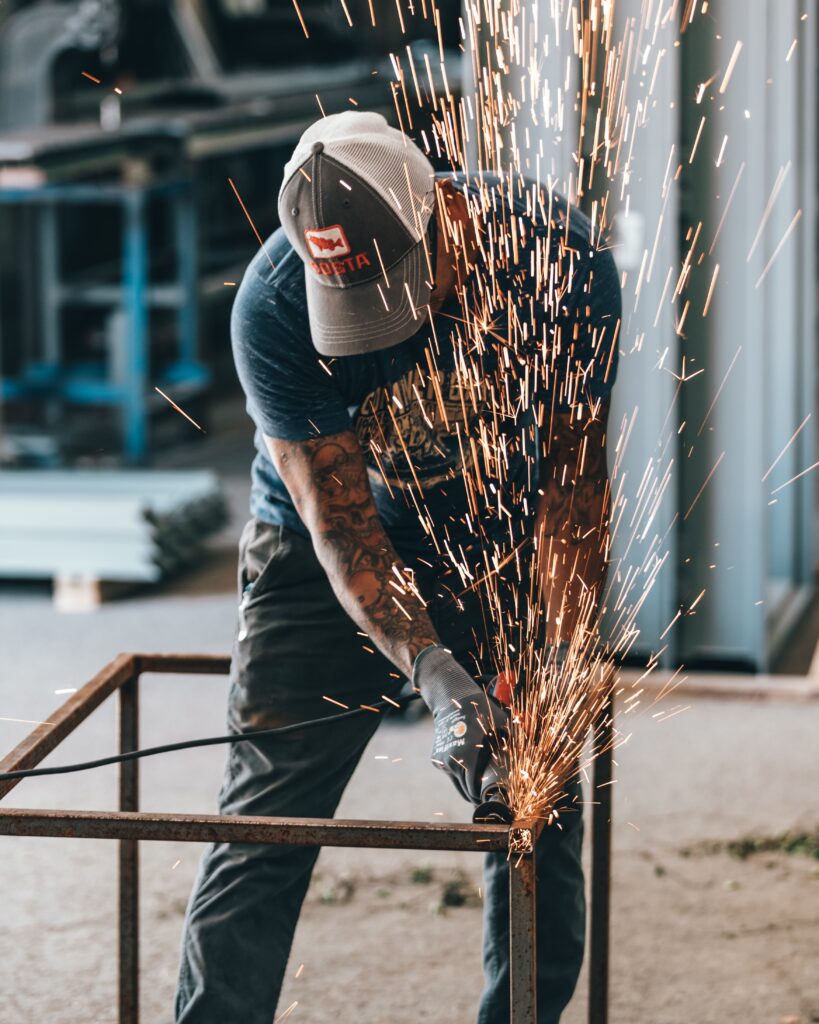 man cutting steel with cutoff tool